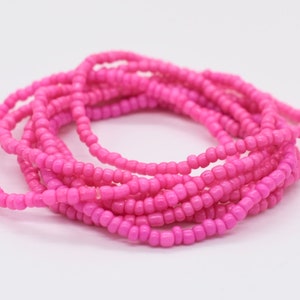 Puede incluir: Un conjunto de pulseras de cuentas rosadas. Las pulseras est&aacute;n hechas de peque&ntilde;as cuentas redondas que est&aacute;n enhebradas en un cord&oacute;n delgado.