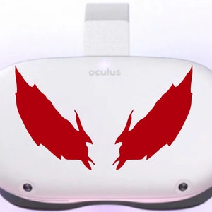 May include: A white Oculus Quest 2 virtual reality headset with a red, stylized wing design on the front. The text "oculus" is printed on the headset.