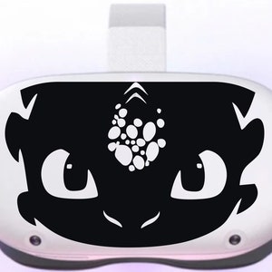 May include: Black and white decal of a dragon's face with a white spot pattern on its forehead. The decal is designed to fit on a virtual reality headset.