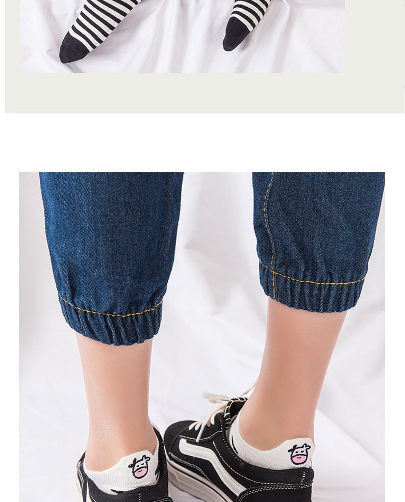 Pu&ograve; includere: Scarpe da ginnastica bianche e nere con calzini bianchi con una grafica di una mucca. I calzini sono abbinati a pantaloni cropped in denim blu scuro con polsini elasticizzati. La parte superiore dell'immagine mostra calzini a righe bianche e nere.