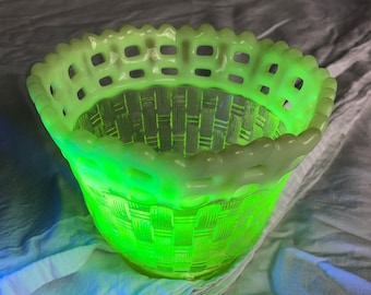 May include: A green glass bowl with a woven pattern and a scalloped rim. The bowl is made of uranium glass and glows under a black light.
