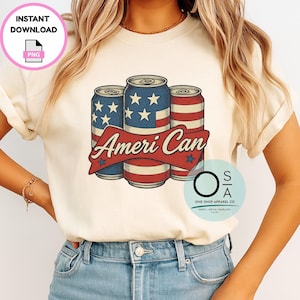 Puede incluir: Camiseta color crema con un gráfico de tres latas de bebidas con un diseño patriótico. Las latas son azules con estrellas blancas y rayas rojas y blancas, con el texto "Ameri Can" en una pancarta roja.
