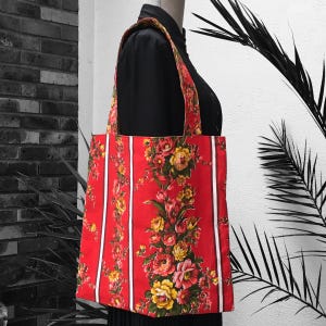 Wendbare Einkaufstasche für Damen aus gefüttertem Vintage-Canvas im Stil der 1960er Jahre mit Girlanden aus rosa, gelben und roten Blumen auf rotem Hintergrund