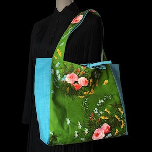 Wendbare, gefütterte XL-Einkaufstasche für Damen aus Vintage-Stoff der 1940er bis 1960er Jahre mit blau-gelb-rosa Blumen auf grünem Hintergrund und blauer Gingham-Rückseite