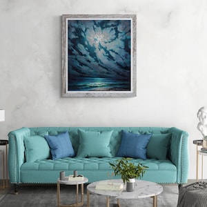 May include: A framed painting of a dark blue night sky with clouds and a bright moon shining through. The ocean is visible in the distance, with a beach in the foreground.