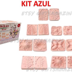 Puede incluir: Una caja de moldes Thikas Azul para flores artificiales, con el texto "KIT AZUL" en la parte superior. La caja es blanca con texto rojo y verde. Se muestran varios moldes rosas con varios dise&ntilde;os florales y de hojas.