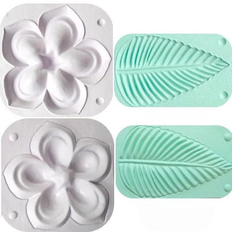 Puede incluir: Dos moldes de silicona blancos para hornear. Un molde tiene forma de flor con cinco p&eacute;talos. El otro molde tiene forma de hoja con un patr&oacute;n de nervaduras detallado.