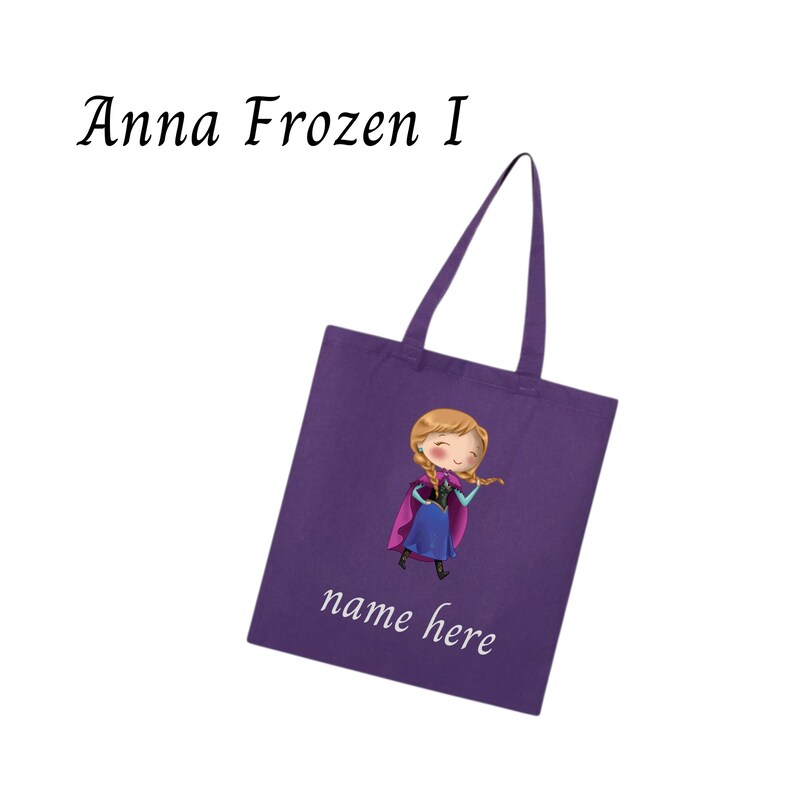 Puede incluir: Un bolso tote morado con una ilustraci&oacute;n de dibujos animados de Anna de Frozen. El bolso tiene asas largas y el texto "Anna Frozen I" en la parte superior y "name here" en la parte inferior en escritura blanca.