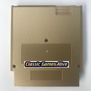 May include: A gold-colored video game cartridge with a textured surface. The cartridge has a rectangular label with the text "Classic Games Alive" in a stylized font. The cartridge has a rectangular shape with rounded corners.