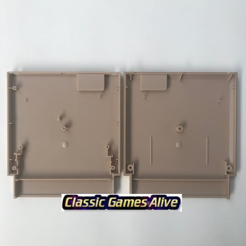 May include: Two tan-colored, empty Nintendo Entertainment System (NES) cartridge shells. Each shell has a rectangular shape with various internal features, including posts and slots. The text "Classic Games Alive" is visible at the bottom.