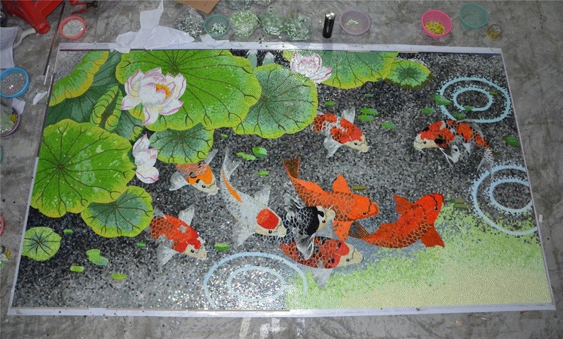 May include: A mosaic art piece depicting a pond scene with colorful koi fish swimming among lily pads and water ripples. The mosaic is made of small, colorful glass tiles.
