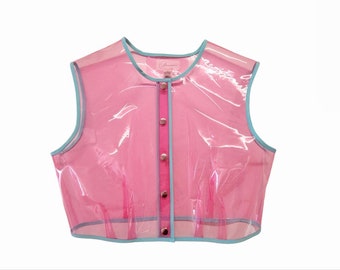 Può includere: Un gilet trasparente rosa senza maniche con bordatura blu e chiusura con bottoni.