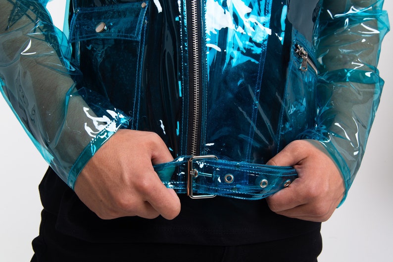 May include: A transparent blue jacket with a black zip and a silver buckle belt.