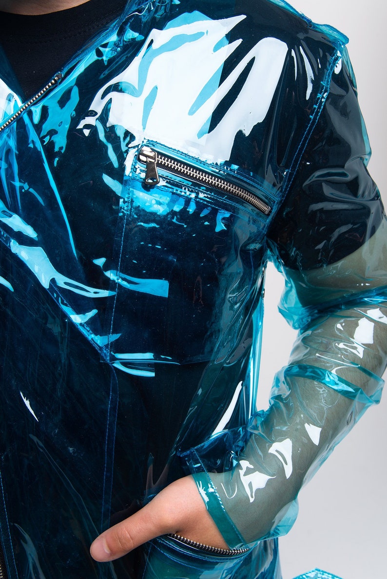 May include: A transparent blue jacket with zippered pockets. The jacket is made of a shiny, plastic-like material.