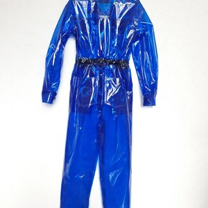 A bright blue, transparent overall with a collared shirt and long sleeves. The jumpsuit has a rubber belt and pockets.