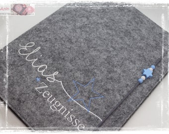 May include: A gray felt folder with the words "Elias Zeugnisse" embroidered in white. A blue star with white beads is attached to the folder.