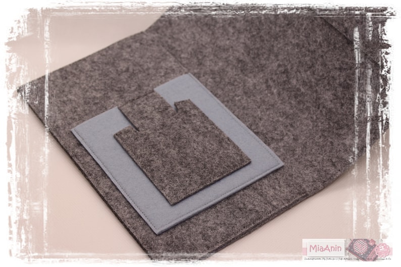 May include: A grey felt pouch with a smaller grey felt pocket inside. The pouch has a flap that folds over the pocket.