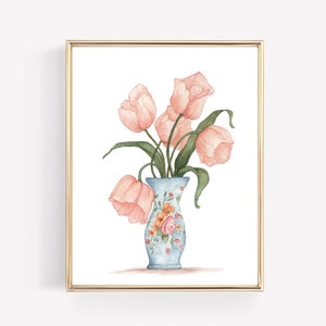May include: Watercolor painting of pink tulips in a light blue vase with floral accents. The vase is set against a white background and framed in a gold border. The artwork is a decorative piece.
