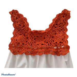 May include: A white sleeveless top with a crocheted orange neckline. The crochet is detailed with a scalloped edge.