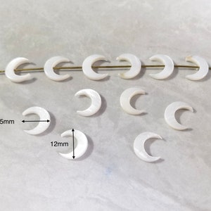Puede incluir: Cuentas de madreperla blanca en forma de media luna, de 10,5 mm y 12 mm de tamaño. Las cuentas están enhebradas en un alambre dorado.