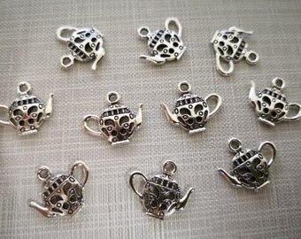 May include: Ten silver teapot charms with intricate designs. The charms are perfect for adding a touch of whimsy to jewelry or crafts.