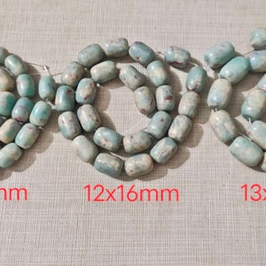 May include: Three strands of turquoise and white oval-shaped beads with red and white marbling. The beads are arranged in a circle and labeled with their size in millimeters: 10x14mm, 12x16mm, and 13x18mm.