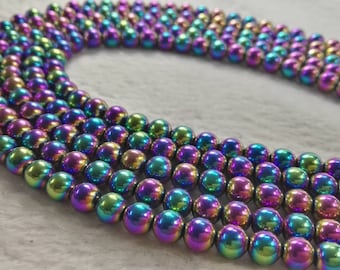 May include: A strand of iridescent rainbow hematite beads. The beads are round and smooth, with a metallic finish. The beads are strung on a clear thread.