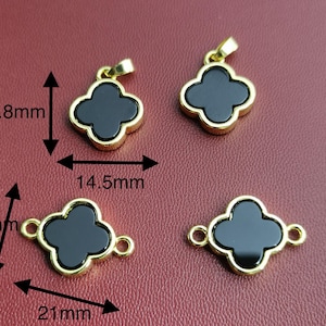 May include: Four gold-tone clover charms with black onyx centers. The charms are 1.45 inches wide and 1.78 inches tall. One charm is a pendant with a loop at the top. The other three charms have a loop on each side.