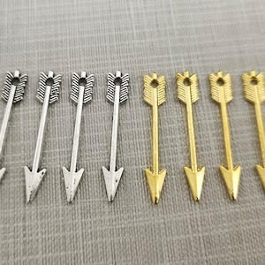以下が含まれることがあります： シンプルなデザインの銀色の矢のチャームが4つと金色の矢のチャームが4つ、計8つのチャームです。矢の長さは約2.5cmで、上部に穴が開いており、ジュエリーやその他のクラフトに付けることができます。