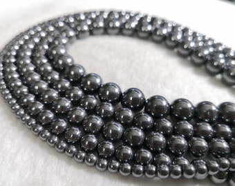May include: A set of six strands of black hematite beads, each strand with a different size of beads. The beads are round and have a shiny, metallic finish.