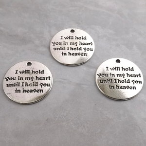 May include: Three circular silver-toned metal charms, each featuring a small hole at the top for attachment. The text "I will hold you in my heart until I hold you in heaven" is engraved in black lettering on the front of each round charm.