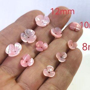 Op de afbeelding: Een verzameling roze schelpbloemvormige kralen in drie maten: 8 mm, 10 mm en 12 mm.