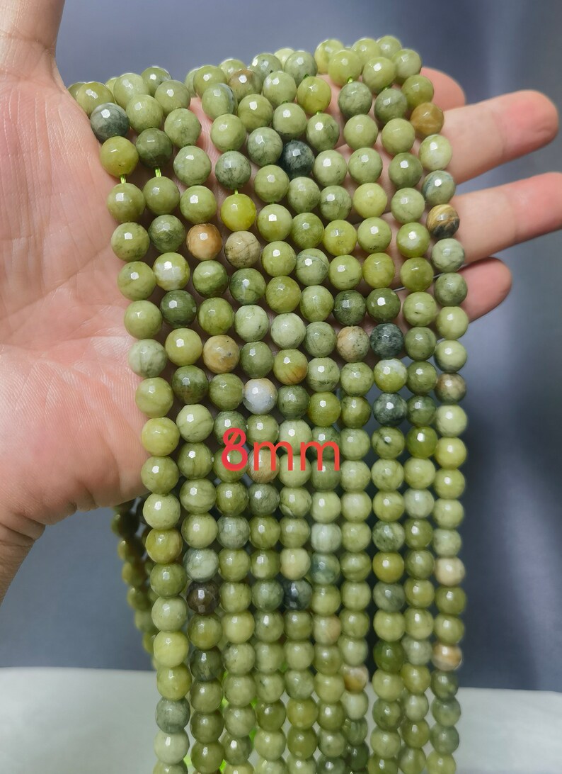 May include: A strand of 8mm green gemstone beads. The beads are round and have a faceted finish.