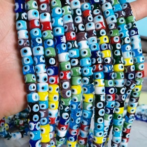 May include: A strand of colorful glass beads with an evil eye design. The beads are a mix of blue, green, red, yellow, and white.