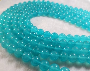 Peut inclure: Un brin de perles de pierres précieuses bleu turquoise. Les perles sont rondes et lisses, avec une finition légèrement translucide.