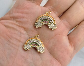 May include: Two gold-tone rainbow charms with clear and colourful crystals. The charms are shaped like rainbows with clouds on each end.