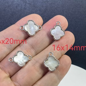 Puede incluir: Cuatro abalorios de trébol de plata con inserciones de madreperla blanca. Los abalorios miden 14x20mm y 16x14mm.