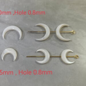 May include: Two sets of white mother of pearl crescent moon shaped beads with a 0.8mm hole. The larger set is 20mm in diameter and the smaller set is 15mm in diameter.
