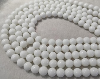 Peut inclure: Un brin de perles rondes blanches, disposées en cercle. Les perles sont lisses et brillantes, de taille et de forme uniformes.
