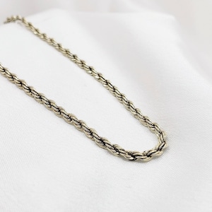 May include: A silver rope chain necklace. The chain is made of a twisted rope design.