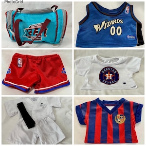 Peut inclure: Ensemble de vêtements et accessoires pour enfants, dont un sac de sport bleu avec des détails rouges et le texte "SUPER X-TREME BOW". Sont également présentés un maillot des Wizards bleu, un short rouge, un t-shirt blanc des Astros, un uniforme de karaté et un maillot de foot rayé.