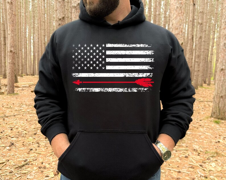 May include: Black hooded sweatshirt with a distressed white American flag and a red arrow across the center.