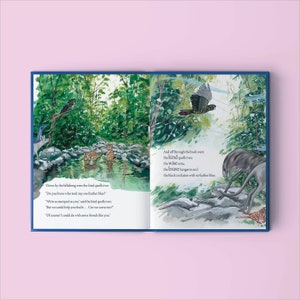 May include: An open book with colorful illustrations of animals in a forest setting. The text on the page reads, "Down by the billabong were the kind quolls two."  "Do you know who took my one feather blue?"  "We're as stamped as you," said the kind quolls two.  "But we could help you find it... Can we come too?"  "Of course! I could do with some friends like you."  "And off through the bush went the kind quolls two, the Wise emu, the brave kangaroo and the black cockatoo with no feather blue."