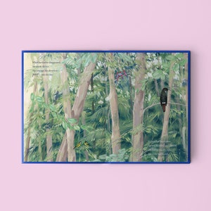 May include: An open book with a blue cover and illustrations of a jungle scene. The text on the page reads "When her feather disappeared, her dazzle did too. Her courage, her cleverness - poof! - into the blue." and "Without her blue feather, she was scared and alone. Her feathers were the only friends she had known."