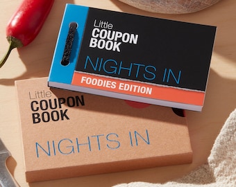 May include: Two "Little Coupon Book" notebooks. One has a black cover with "Nights In Foodies Edition" text. The other is tan with "Nights In" text. A red chili pepper and a knife are also visible.