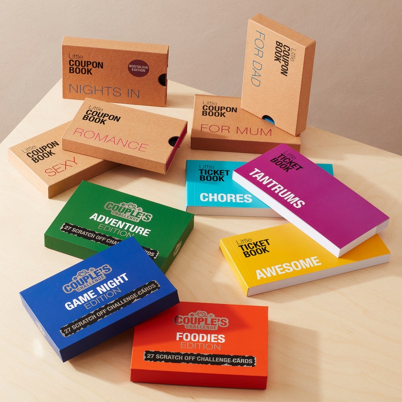 May include: A collection of colorful boxes with different titles, including "Couples Challenge" and "Little Ticket Book". The boxes feature various themes, such as "Adventure", "Game Night", "Foodies", "Tantrums", "Chores", and "Awesome".