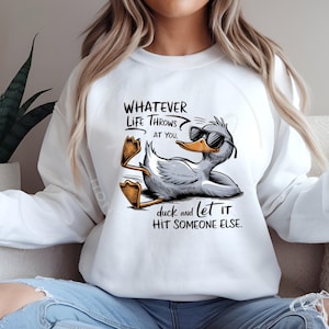 May include: White sweatshirt with a cartoon duck wearing sunglasses and the text "Whatever life throws at you, duck and let it hit someone else."