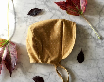 Warm winter beguin with visor, baby lined cap, mustard ochre with white peas