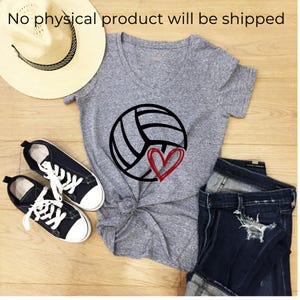 Peut inclure: Un t-shirt gris chin&eacute; &agrave; col en V avec un motif de ballon de volley-ball noir et un c&oelig;ur rouge. L'article est pr&eacute;sent&eacute; avec un chapeau de paille, des baskets noires &agrave; lacets blancs et un jean bleu fonc&eacute; us&eacute;. Le texte indique : No physical product will be shipped.