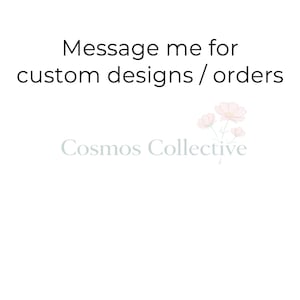 May include: A white graphic sign featuring the black text Message me for custom designs / orders at the top. Below this, the light gray text Cosmos Collective is displayed alongside a small illustration of three pale pink cosmos flowers.